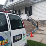 Carpet cleaning truck with hoses run into home